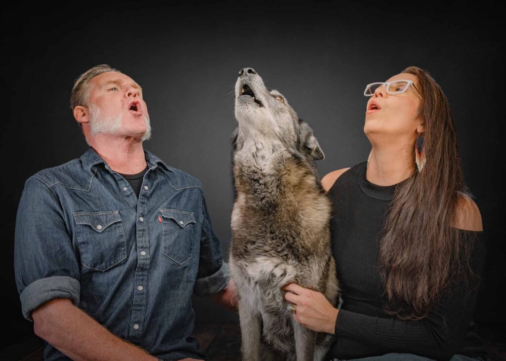 couple howling with their husky dog in studio